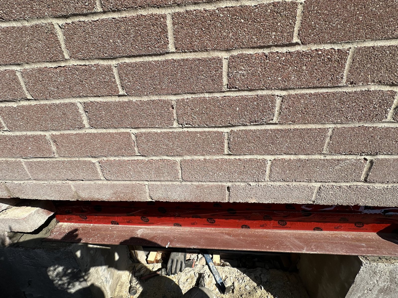 New steel lintel installed beneath brickwork during patio door opening construction