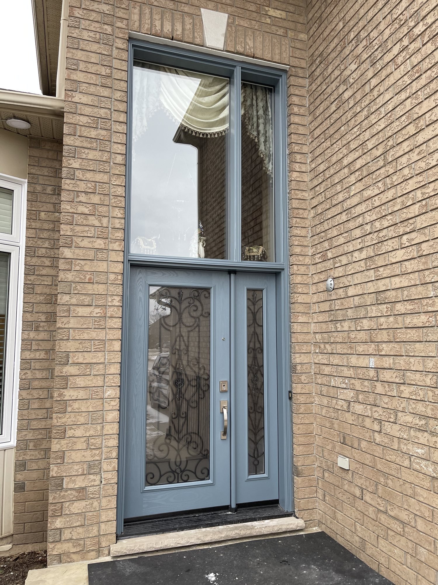 Slate-blue decorative-glass entrance system in a Stoney Creek brick home